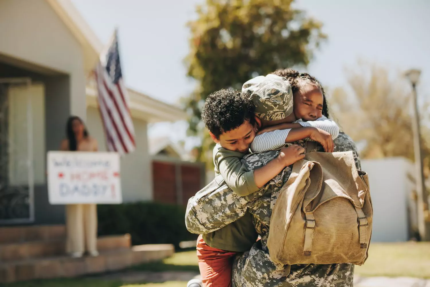Soldier greeted by his children in front of their new home